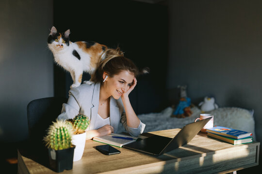 Girl working at home with her cat.