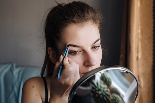 Woman correcting eyebrow.