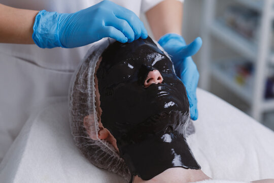 Hand removing alginate facial mask.