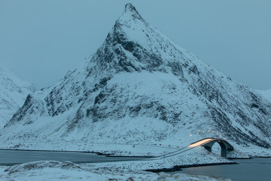 Bridge over the fjord against the backdrop of a snowy mountain