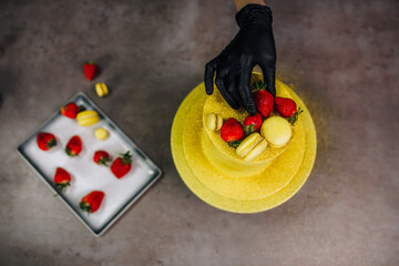 Chef creating yellow fruit cake at bakery for customer order