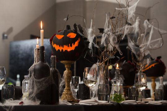 Table set for Halloween dinner. Served holiday table with candles and pumpkin