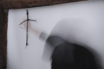 A horror concept of a hooded figure and wooden cross
