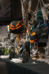 Table set for Halloween dinner. Served holiday table with candles and pumpkin