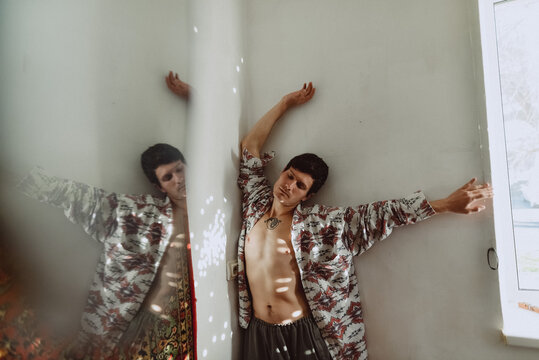 Young man dancing on a white wall background