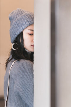 A Chinese beauty half face behind the wall