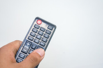 Male hand holding a tv controller on a blank background