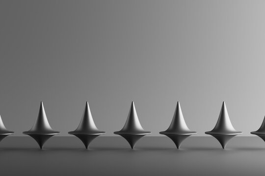 Three dimensional render of row of metallic spinning tops