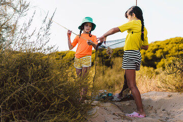 Friends picking up waste garbage thrown on beach