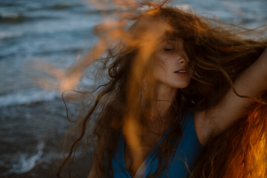 Young Woman Face Covered With Hair While Dancing At Beach