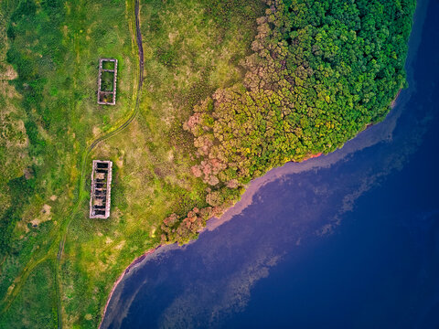 Drone shot of old buildings on green land by Novgorodskaya bay at Primorsky region, Russia