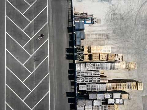 Drone view of man lying on back in empty parking lot