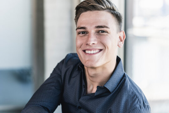 Close-up Of Smiling Handsome Professional Sitting In Office