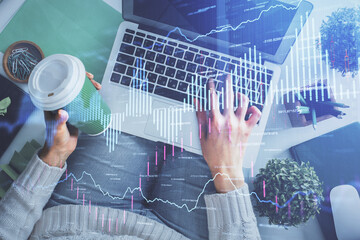 Double exposure of woman hands working on computer and forex chart hologram drawing. Top View. Financial analysis concept.