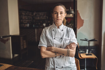 Portrait of chef with arms crossed standing in restaurant