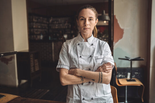 Portrait of chef with arms crossed standing in restaurant