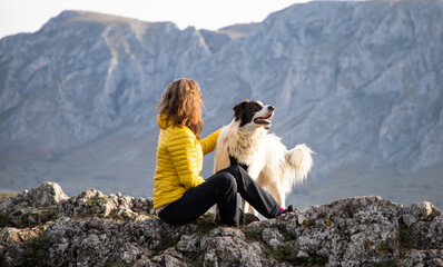 woman on mountain top with dog social distancing