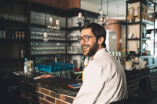 Side view of happy chef sitting in restaurant
