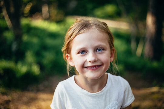 Portrait of cute smiling girl standing in forest