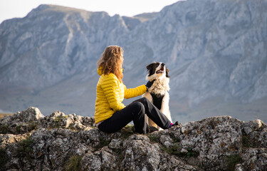 woman on mountain top with dog social distancing