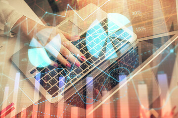 Double exposure of woman hands typing on computer and financial graph hologram drawing. Stock market analysis concept.