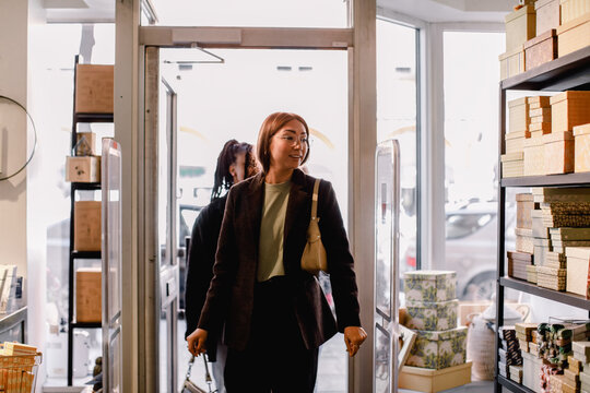Smiling female friends entering retail store