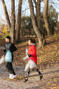Male and female environmentalists plogging in park