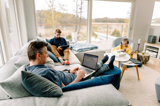 High angle view of father and children using wireless technology at home