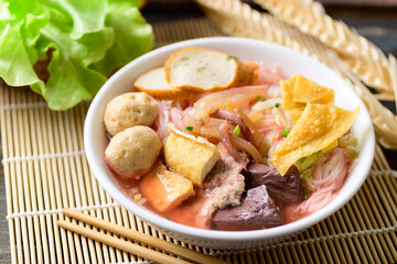 Thai food (Yen Ta Fo), Rice noodles soup with red sauce and fish tofu, pork ball and fried wonton in a bowl