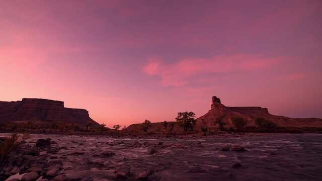 Sunrise time lapse over the Green River at Swaseys Beach in Utah as the colors change vibrant shades in the sky.