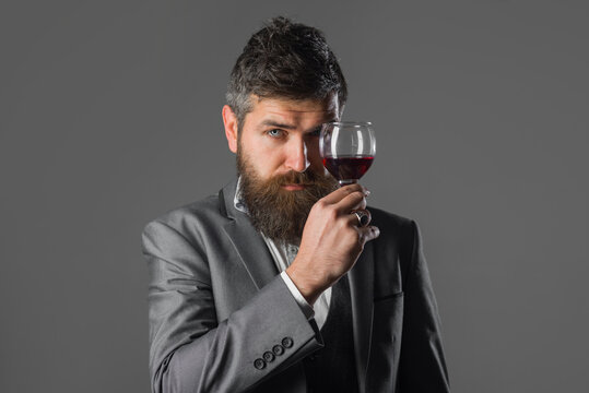 Wine. Bearded man with glass of wine. Tasting alcohol. Red wine. Bearded man with alcohol. Man in suit drinks wine. Man with Bordeaux.