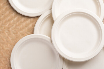 Biodegradable, Compostable or Eco friendly disposable plate on woven bamboo background, sustainable concept
