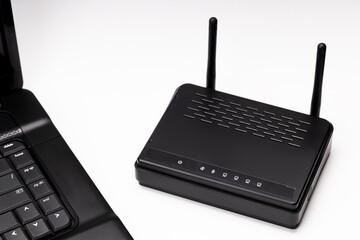 black wifi router and laptop over white background. online and network conceptual. copy space....