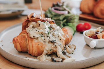 Tasty Himeji Mushroom cream sauce croissant sandwich with herbs and mushrooms. Breakfast in cafe.