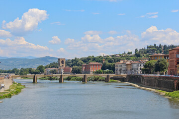 Fototapeta premium View down a river in Florence, Italy with bridge in the distance. No people, space for copy.