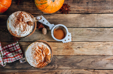 Pumpkin spiced latte or coffee in a glass on a vintage table. Autumn or winter hot drink.