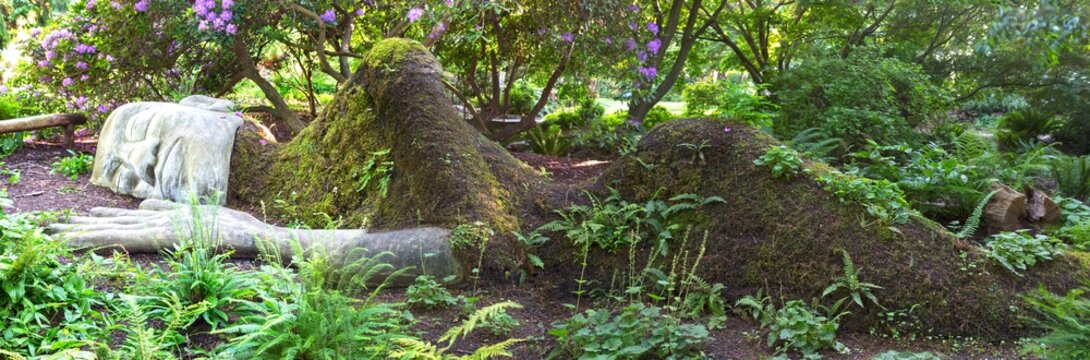 The Moss Lady in Victoria, BC Beacon Hill Park on June 15, 2019. Created by gardener Dale Doebert, it portrays sleeping moss-covered woman partly submerged in Earth