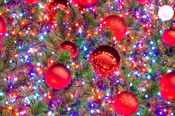 red balls on the Christmas tree with red light bulbs, selective focus