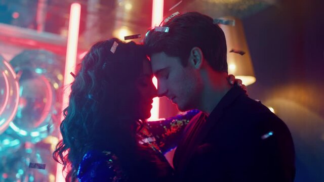 Affectionate guy and girl touching foreheads in club. Couple moving at party
