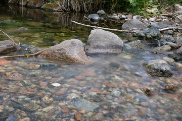 Slow shot of the clear stream flowing in the outdoor mountain