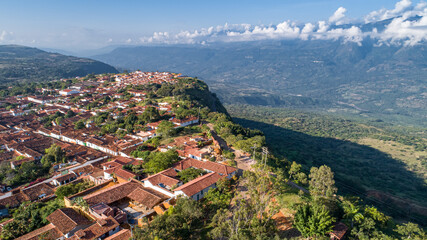 Aerial view panorama of historic town Barichara, Colombia with white cloud covered mountain ridge in background