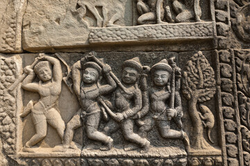 Ancient bas-relief on the wall of the famous Angkor temple. Figures of people, animals, wood are carved on the stone. Ornament around the perimeter. Unesco heritage. Cambodia.