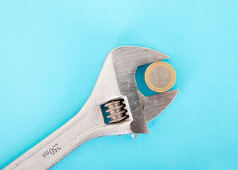 A pair of live-nose pliers on a blue background to hold a one-euro coin