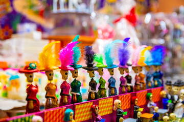 Traditional Mexican ornamental figurines, (toys, home decorations etc.) displayed for sale at a stall at the Feria del Alfeique in Toluca, Mexico (catrina)