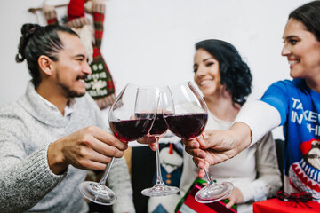 Hands holding red wine glasses on mexican Christmas dinner