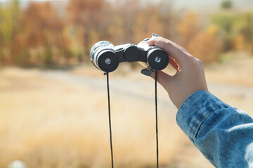 Young girl with binoculars in the high mountains.