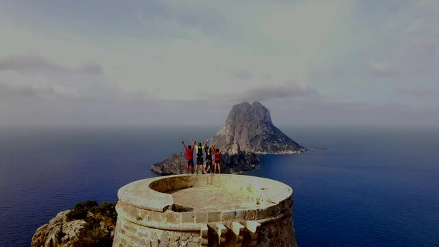 La torre del pirata (Pirate's Tower) and Es Vedra air shot in Ibiza spain with people raising hands