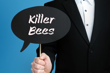 Killer Bees. Businessman holds speech bubble in his hand. Handwritten Word/Text on sign.