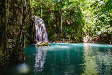 Beautiful blue waterfall with fish swimming in Tropical  forest at Erawan waterfall National Park Kanchanaburi, Thailand.