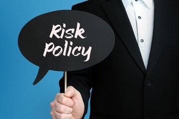 Risk Policy. Businessman holds speech bubble in his hand. Handwritten Word/Text on sign.